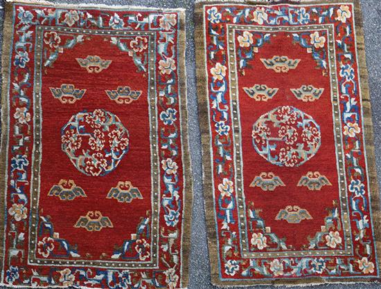 A near pair of Tibetan red ground rugs, 4ft 7in. x 2ft 3in. and 4ft 5in. x 2ft 10in.